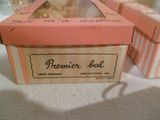a pink box with a teddy bear inside of it