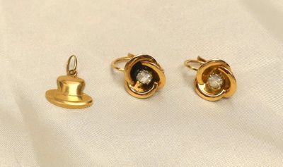 three pairs of gold and diamond earrings on a white cloth
