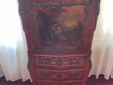 a wooden cabinet with a painting on it in the corner of a room