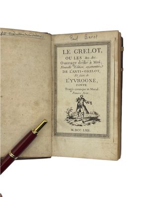an old book with a pen sitting on top of it next to a pen