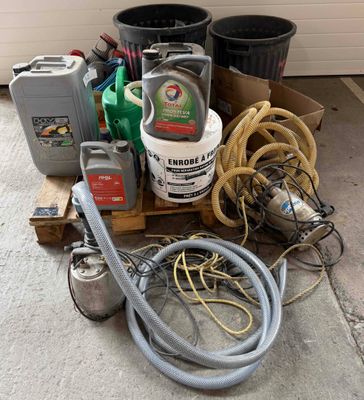 a pile of junk on the ground next to some cans and hoses