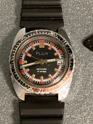 a watch that is sitting on a table next to a cell phone