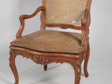 a wooden chair with a cane back and a tan seat