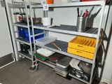 une étagère métallique sur laquelle sont disposés de nombreux objets divers