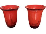 two red vases sitting next to each other on a white surface