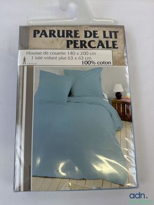 emballage d'un lit avec une couette bleue et deux oreillers