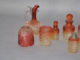 five different colored glass bottles sitting on a white surface