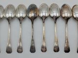 six spoons are lined up in a row on a white surface