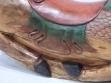 a wooden sculpture of a fish with a saddle on it ' s back