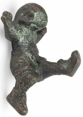 une figurine en bronze représentant un garçon jouant avec un frisbee