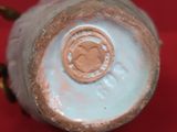 un vase blanc avec une anse dorée sur un fond rouge