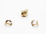 trois paires de boucles d'oreilles en or et une bague en or posées sur un fond blanc