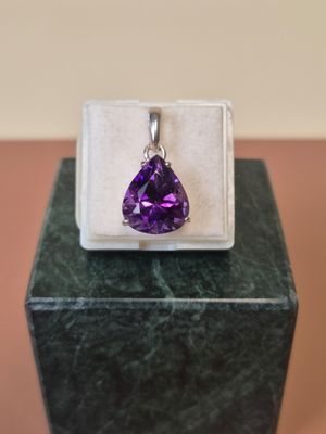 un gros plan d'un pendentif serti d'une pierre violette