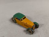 une petite voiture jaune et verte posée sur un sol recouvert de neige