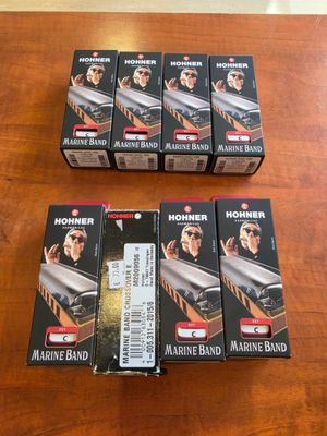 four boxes of hohner marine band harmonicas sitting on a table