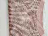 a pink sweater in a plastic bag on a table