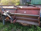 une grosse machine rouge qui est garée dans l'herbe