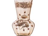 a glass vase with a dragon on it on a white surface