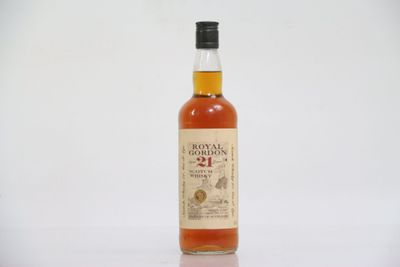 La bouteille de whisky est posée sur une surface blanche.