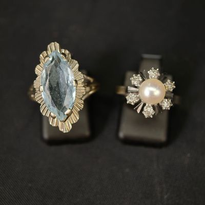 deux bagues ornées d'une topaze bleue et d'une perle sur un fond noir