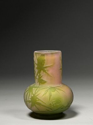 un vase vert orné d'un motif, posé sur une table