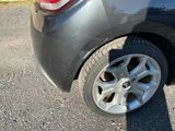 une voiture noire avec un chat assis à l'arrière