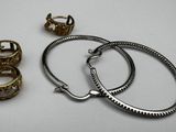 two rings and a bracelet are sitting on a white surface
