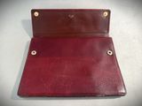 a close up of a red leather wallet on a white surface