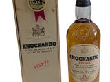 un gros plan sur une bouteille de whisky Knockando à côté d'une boîte