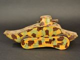 an old wooden toy tank sitting on top of a black surface