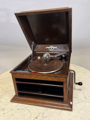 un vieux tourne-disque posé sur une table, à côté d'une télécommande