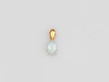 une photo d'un pendentif plaqué or orné d'une topaze bleue