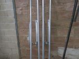 four poles that are leaning against a brick wall