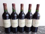 six bottles of wine are lined up on a table