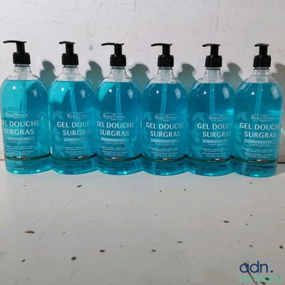 six bouteilles contenant un liquide bleu posées sur un comptoir