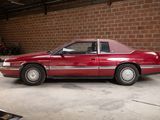 a red car parked in a garage next to a brick wall