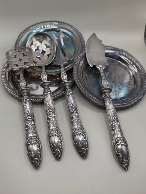 trois cuillères en argent et une assiette en argent sur le comptoir