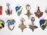 un assortiment de badges métalliques de différentes formes sur un fond blanc