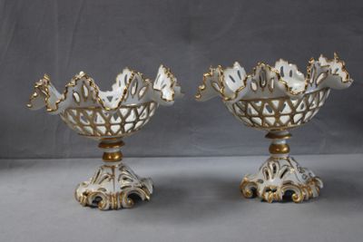 deux vases blancs et dorés ornés de fleurs, posés sur une table
