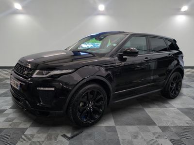 un Range Rover noir garé sur un sol à damier dans un garage