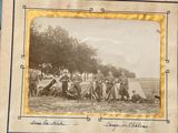 an old photo of a group of people sitting in a field