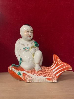 a figurine of a man sitting on a fish