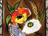 a picture of a tile with flowers and wheat on it