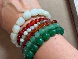 a woman ' s hand holding a bunch of bracelets