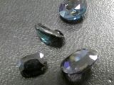 some very pretty blue and clear crystals sitting on a black surface