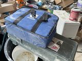 a blue suitcase sitting on top of a cart in a messy room