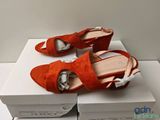 an image of a pair of orange shoes sitting on top of a box