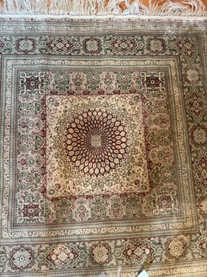 un tapis oriental orné d'un motif en médaillon posé sur un parquet