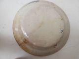 a white bowl with a brown lid on a table