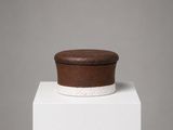 a small brown box sitting on top of a white pedestal